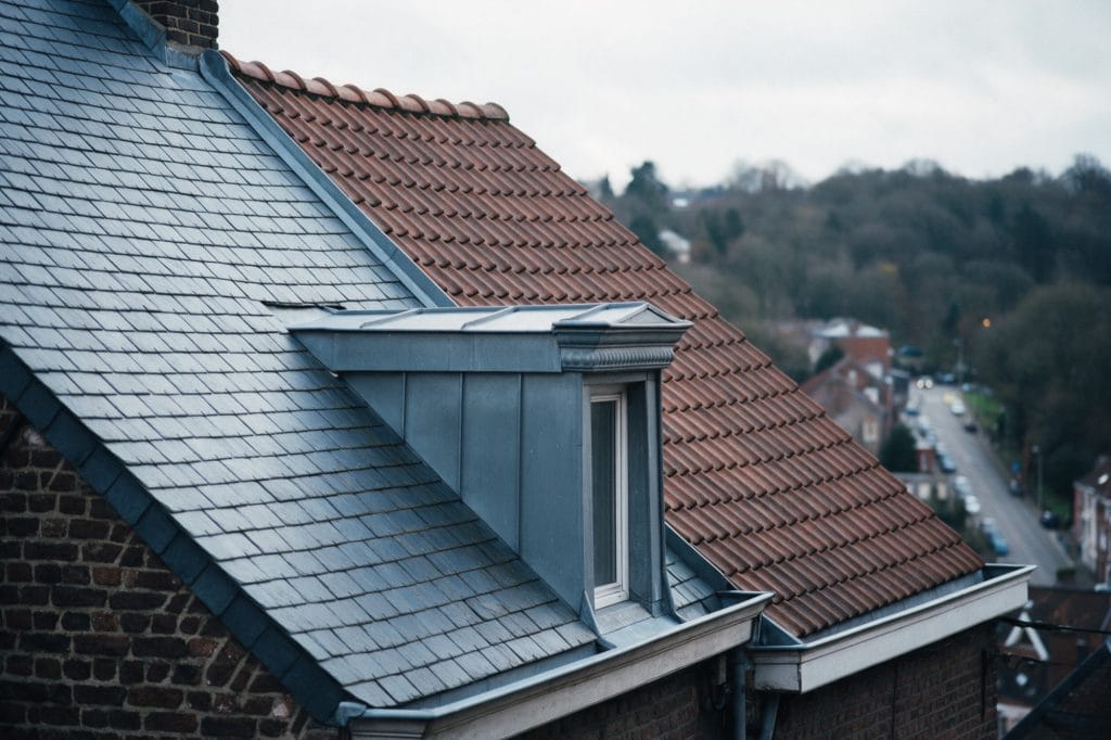 Toits liégeois voisins en ardoise naturelle et tuile panne avec lucarne habillée de zinc